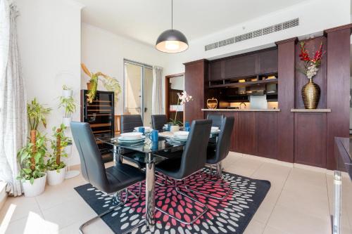 a dining room with a glass table and black chairs at Incredible Fountain Views 2.5 BR Burj Residences in Dubai