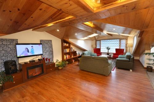 a large living room with a flat screen tv at The Retreat Mashobra, Shimla in Shimla
