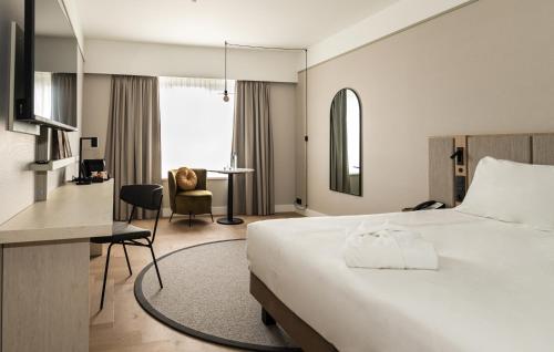 Habitación de hotel con cama y escritorio en Mercure Liege City Centre en Lieja