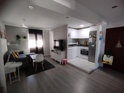 Apartamento acogedor. في Gelves: غرفة معيشة مع أريكة ومطبخ