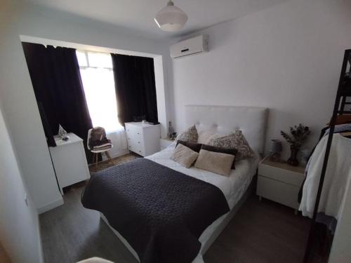 a bedroom with a bed with a black blanket at Apartamento acogedor. in Gelves