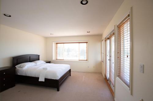 1 dormitorio con 1 cama y 2 ventanas en North Vancouver Haven:Where Comfort Meet Adventure, en North Vancouver