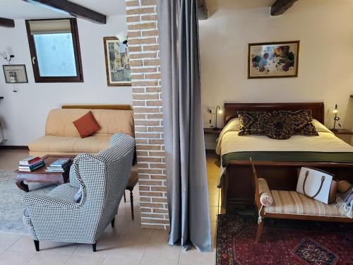 瓦爾瑪德雷拉的住宿－Relais Garden Lecco，一间卧室配有一张床、一张沙发和一把椅子