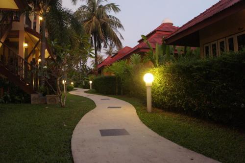 a walkway with lights on the side of a house at Palm Village in Rawai Beach