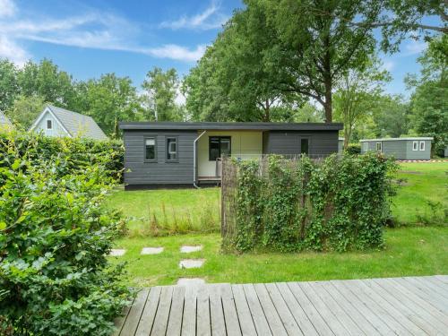 a tiny house in a yard with a fence at Comfortable holiday home in Den Ham with garden in Den Ham