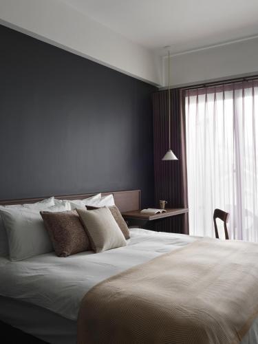 Una cama o camas en una habitación de 廷海特潮流民宿 武昌館 民宿編號2015 寵物友善設計旅宿 近微光集與鐵道藝術村