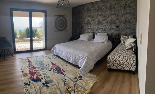 a bedroom with a bed and a window and a rug at EMERAUDE in Saint-Cast-le-Guildo