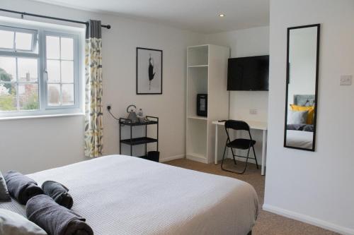 een slaapkamer met een bed, een bureau en een raam bij The Live and Let Live in Downham Market