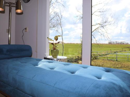 a blue bed in a room with a large window at Secluded Chalet in Suwald with Hottub in Warstiens