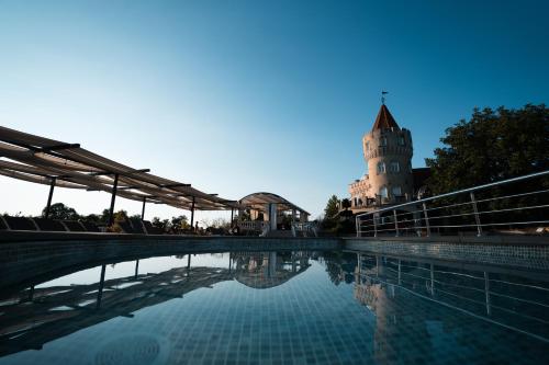 a pool of water with a building in the background at Sobor Family Resort in Stavcheny