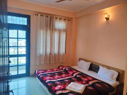 a bedroom with a bed and a large window at The Anand with Ganga View and Rooftop Cafe in Rishīkesh