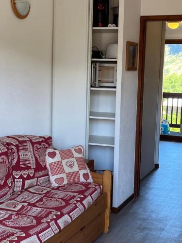une chambre avec un lit et une étagère dans l'établissement La Balcons d olympie, aux Menuires