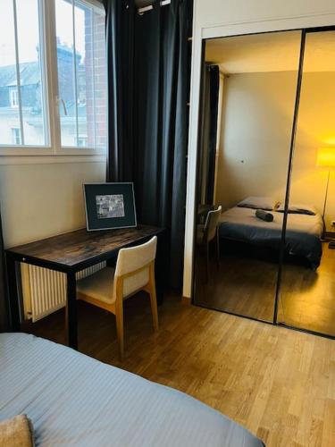 een slaapkamer met een bureau, een bed en een spiegel bij Superbe Duplex pour 8/10 personnes in Rouen