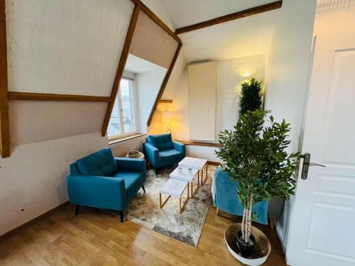 een woonkamer met twee blauwe stoelen en een plant bij Superbe Duplex pour 8/10 personnes in Rouen