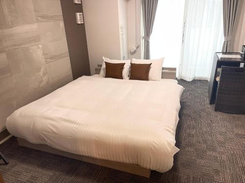 a large white bed in a hotel room at COCOSTAY銀山町リバーサイド,COCOSTAY Kanayamacho riverside, Great location river view-5 min walk from the nearest station in Hiroshima