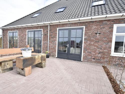 un patio con bancos y un edificio de ladrillo en Studio Hazenborgh in Callantsoog near the sea, en Callantsoog