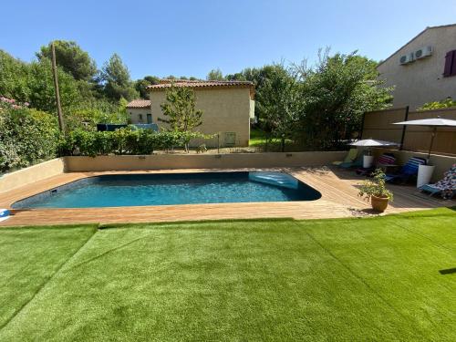 - une piscine dans une cour avec de l'herbe verte dans l'établissement Superbe villa avec piscine, jardin et terrasse aux portes d'Aix en Provence, à Aix-en-Provence