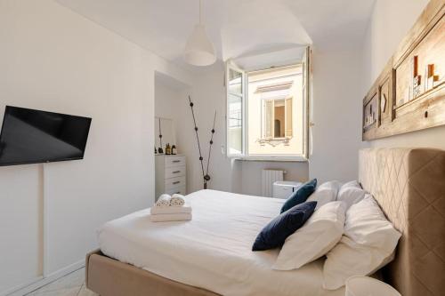 アルバにあるCasa Regina 3, nel centro di Alba!の白いベッドルーム(青い枕の大型ベッド付)
