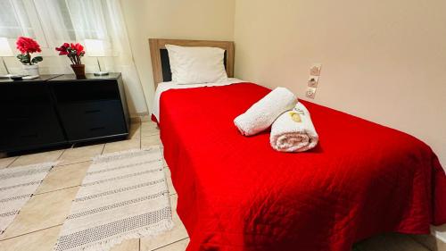 a bedroom with a red bed with two towels on it at Patras Centre Apartment in Patra