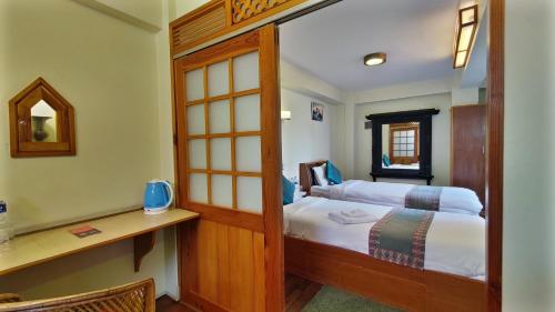 a small bedroom with a bed and a desk at Tiny Haven Apartment at Greentara Heritage Home in Pātan
