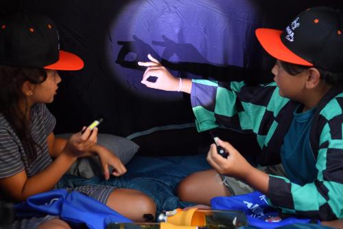 two children sitting on a bed looking at their cell phones at Anantara Vacation Club Mai Khao Phuket in Mai Khao Beach