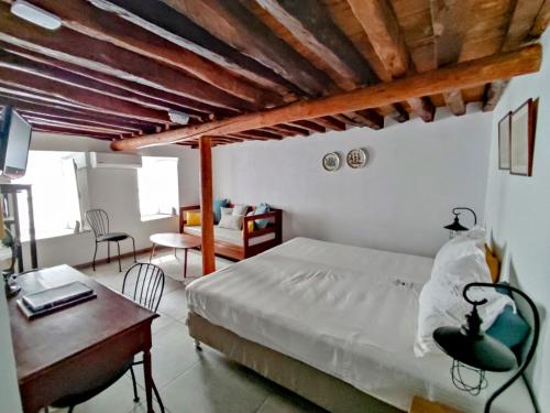 una camera da letto con un letto, un tavolo e una scrivania di Keresbino Hydra Art Suite a Hydra