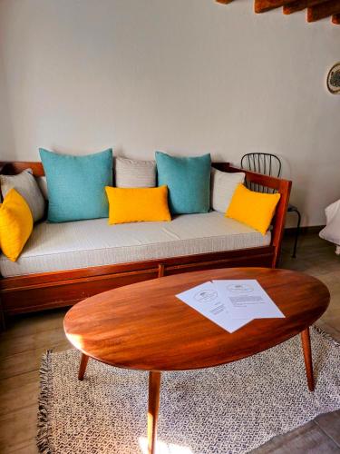a living room with a couch with colorful pillows at Keresbino Hydra Art Suite in Hydra