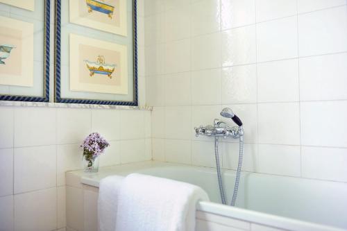 Bucine的住宿－Fattoria Casabianca，白色的浴室设有浴缸和花瓶