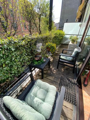 a patio with a couch and a chair on a balcony at Loft Dei Lupi 260m dal Duomo FreeParking in Cremona