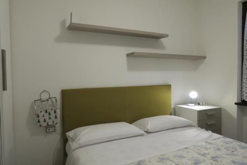 1 cama con cabecero verde en un dormitorio en Appartamento Aila, en Molina di Ledro