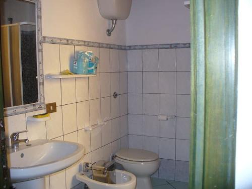 a bathroom with a toilet and a sink at Accogliente Appartamento a pochi passi dal mare in Funtana Meiga