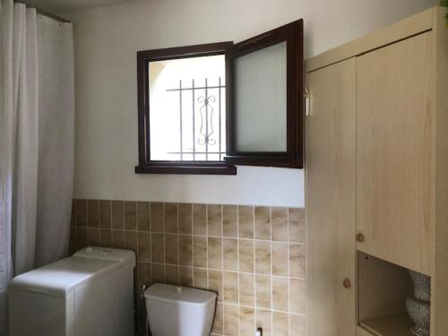 łazienka z toaletą i oknem w obiekcie villa des pins w mieście Tallard