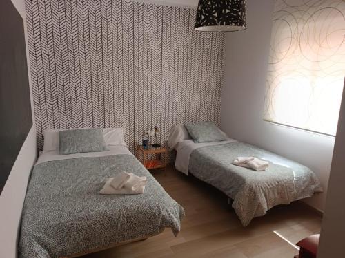 a bedroom with two beds with towels on them at Encarnita's Home in Ardales