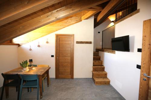 a dining room with a wooden table and a tv at L'abri en ville in Aosta