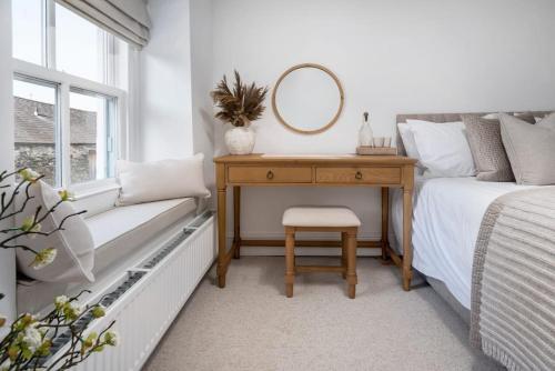 a bedroom with a desk and a bed with a mirror at Wharton Cottage, Lake District Retreat in Cartmel