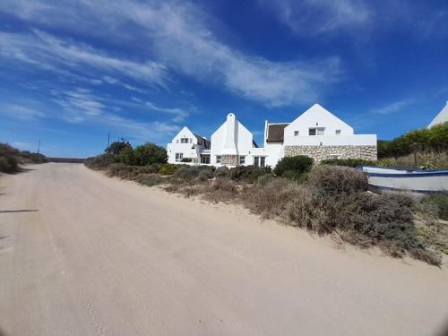 a house on the side of a dirt road at Zeezicht Villa - Jacobsbaai in Jacobs Bay
