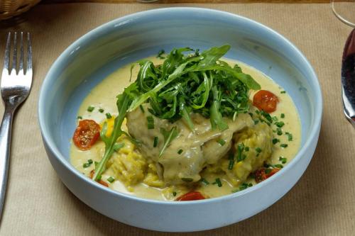 a bowl of food on a table with a plate of food at Contact Hôtel de la Gare et son restaurant Côte à Côte in Autun