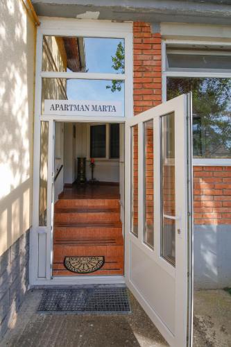 an open door of a building with a sign on it at Apartman Marta i soba Maja in Gradište