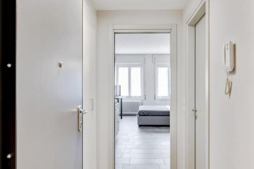 a room with a bed and a door leading to a bedroom at Appartamento Mango - Affitti Brevi Italia in Lecco