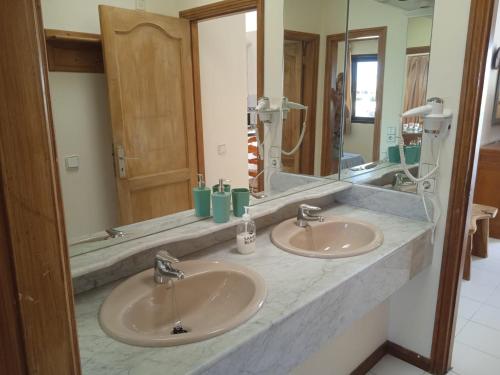 a bathroom with two sinks and a large mirror at MOAMA Beach in Costa Teguise