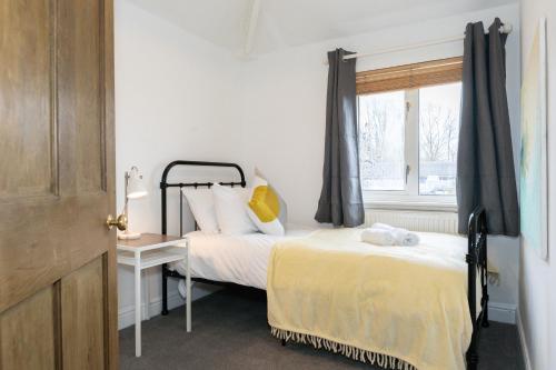 Imagination by Olauda SA - 3 bed House with Free Parking في بريستول: غرفة نوم بسرير ونافذة