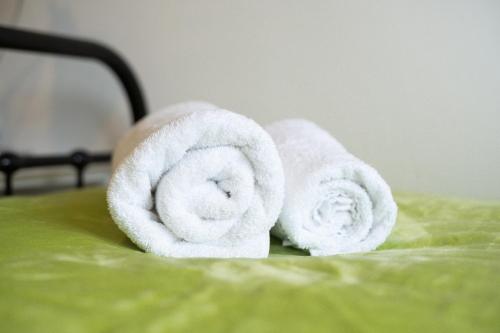 a pair of towels sitting on top of a bed at Imagination by Olauda SA - 3 bed House with Free Parking in Bristol