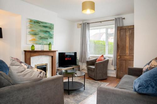a living room with two couches and a fireplace at Imagination by Olauda SA - 3 bed House with Free Parking in Bristol