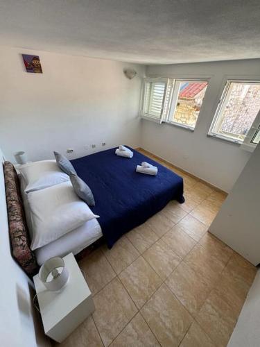 1 dormitorio con 1 cama con sábanas y almohadas azules en Apartment Antonijo en Hvar