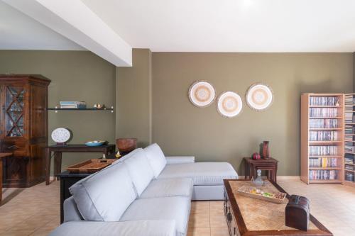 ein Wohnzimmer mit einer weißen Couch und Tellern an der Wand in der Unterkunft Koralia Vacation House in Likotinaréa