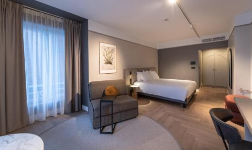 a hotel room with a bed and a couch at Mercure Liege City Centre in Liège