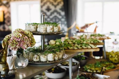 a buffet with several trays of food and flowers at Bauergården in Gränna