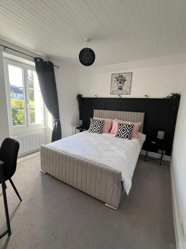 une chambre avec un grand lit avec des oreillers roses dans l'établissement Le Cantou, à Affieux