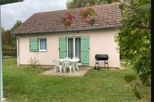 een klein wit huis met groene deuren en een grill bij MAISON Au LAC DU DER '' LES COCCINELLES 41 '' in Giffaumont