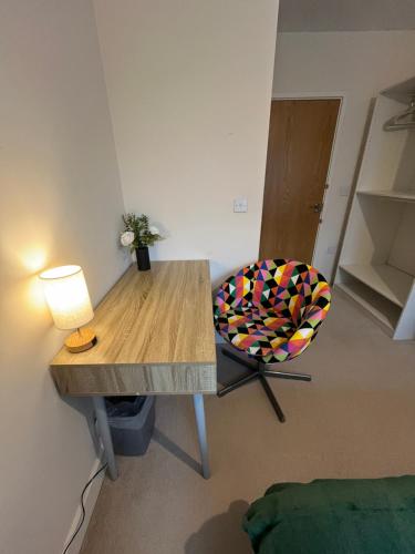 a room with a table and a chair with a lamp at Peaceful shared flat 30mins Central London in Colindale